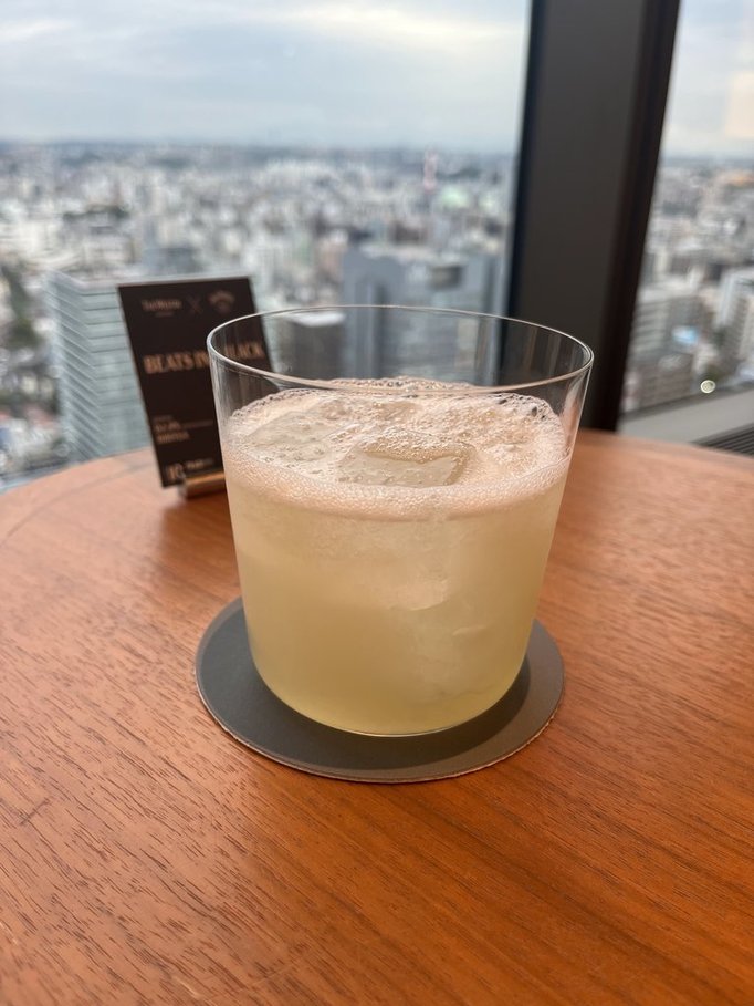 茶色のテーブルに置いてある乳白色のカクテルの写真